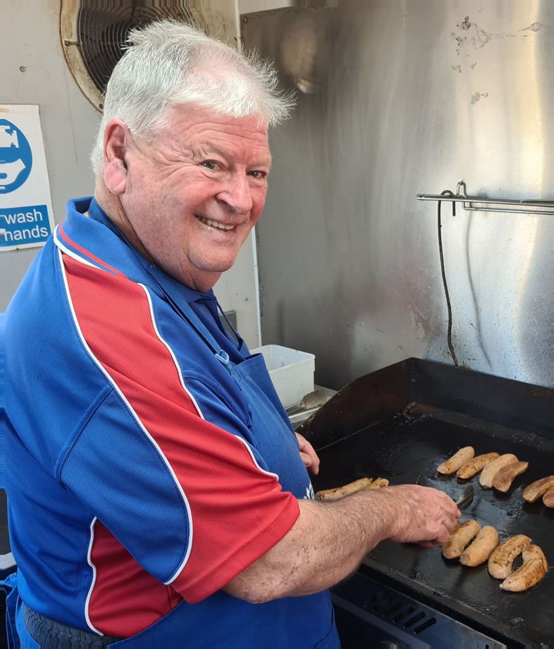 A club member cooking at a fundraising barbecue