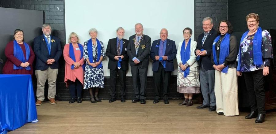 Members on stage at a district induction