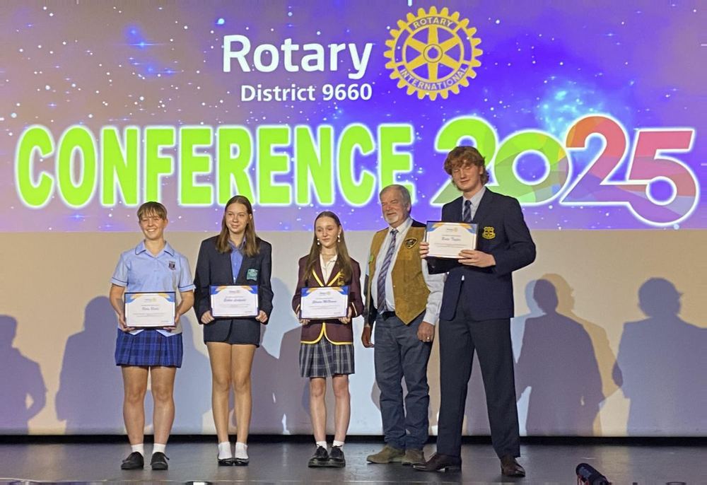 Students receiving public speaking certificates on stage at the District 9660 conference